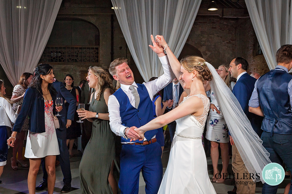 Bride dancing with guests with arms out