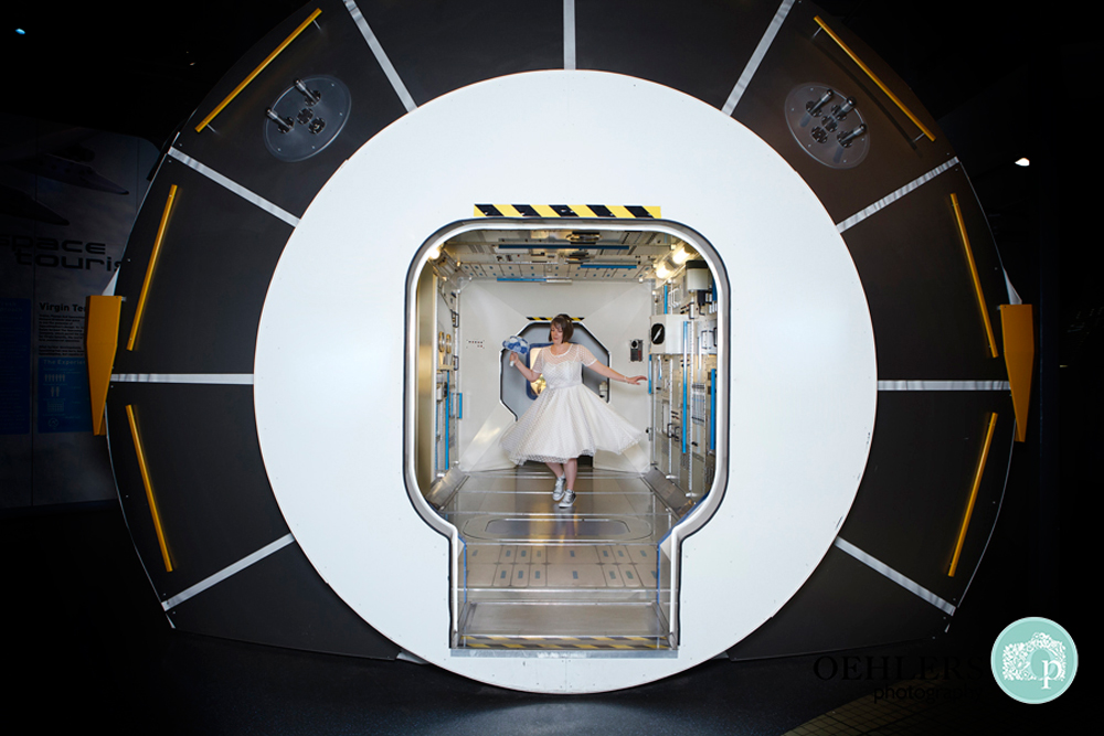 Bride dancing inside a space capsule in The Space Centre in Leicester