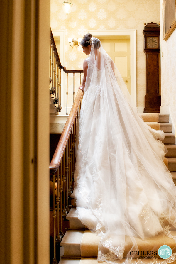 Bride leaning against a staircase