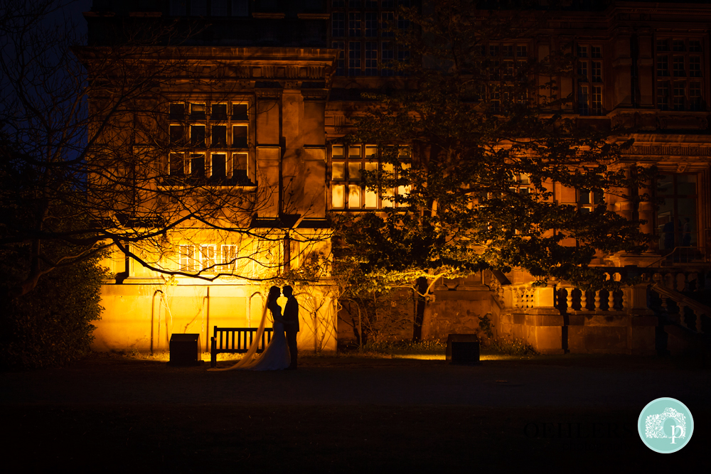 silhouette of Bride and Groom in front of a light at Wollaton Hall