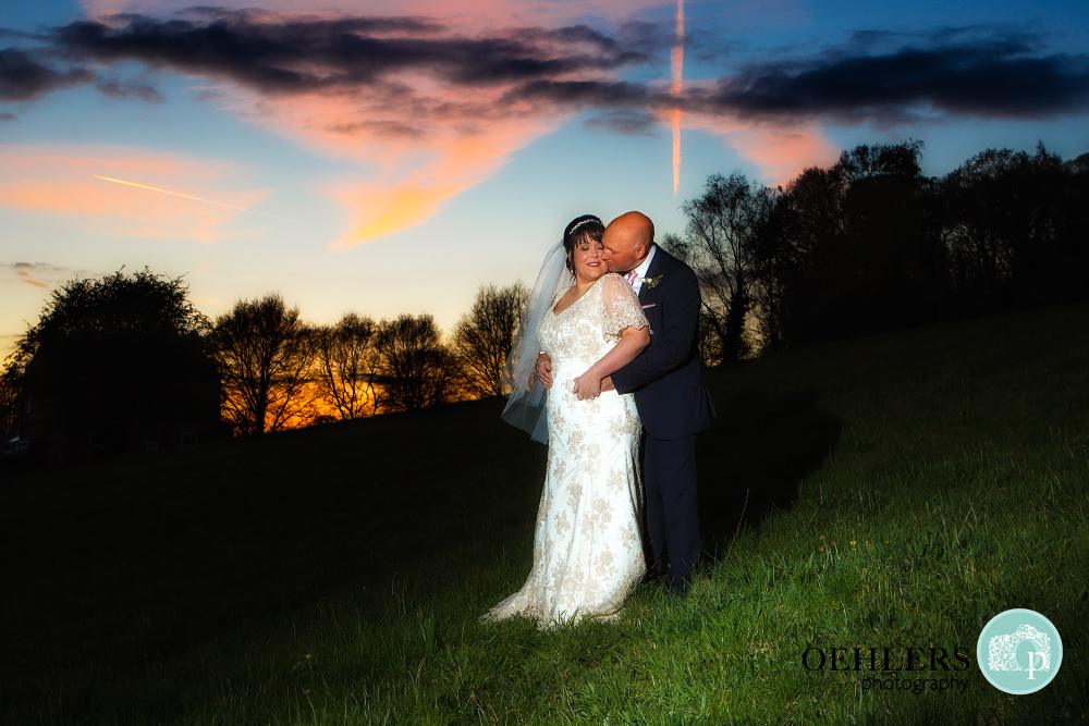 Bride and Groom cuddling with sunset in the background