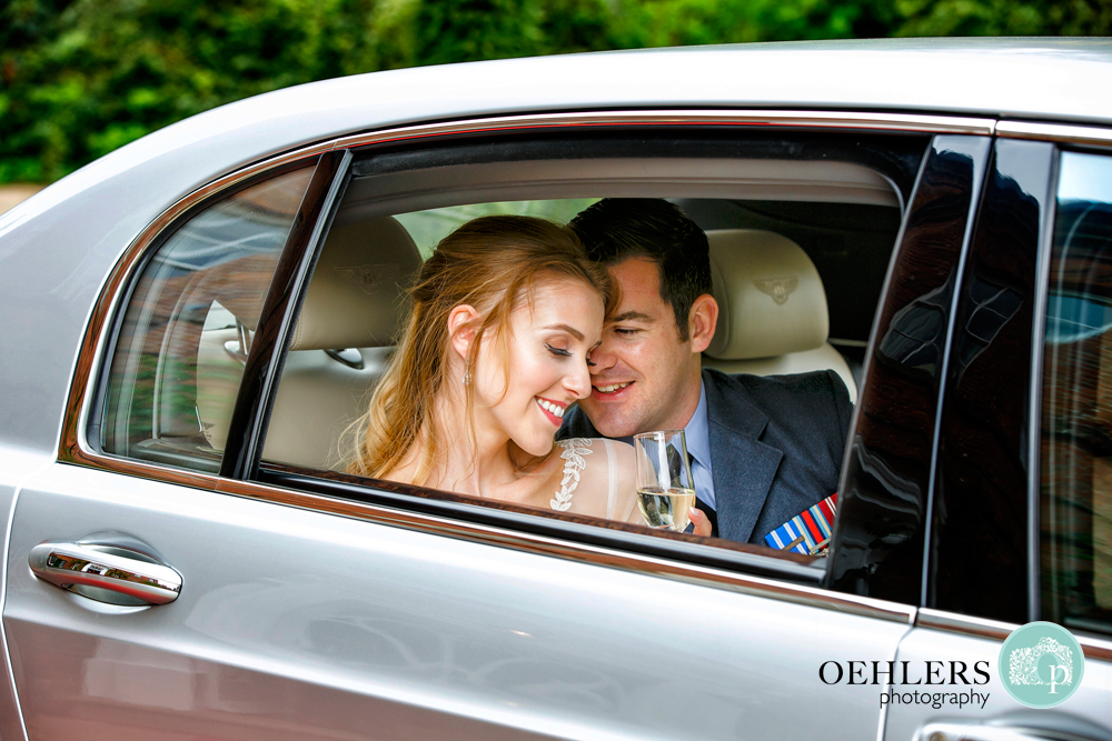 Groom snuggling up to Bride in the wedding car