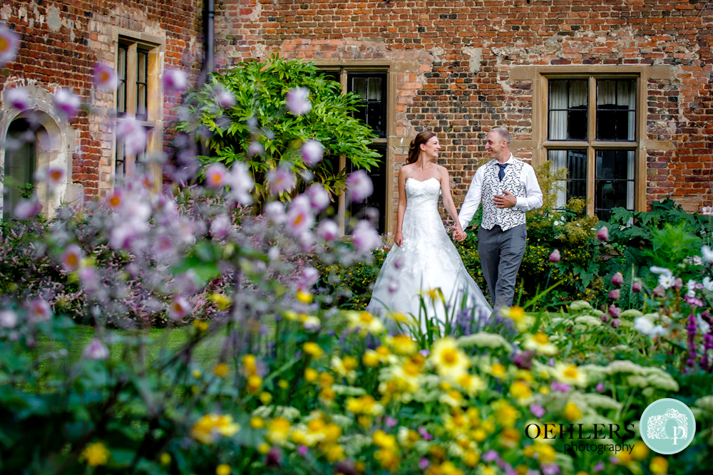 shoot through flowers at bride and groom walking