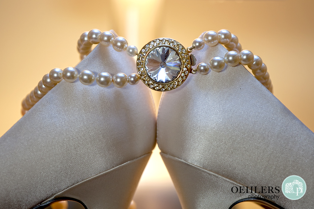 pearl bracelet hanging from wedding shoes