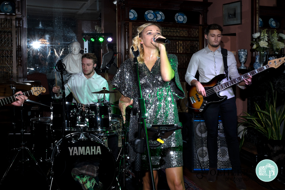 Lead singer with her band in the background entertaining the guests