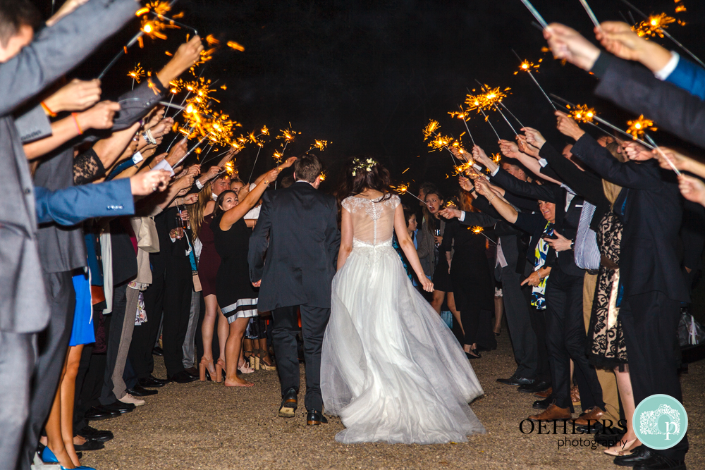 Guests form a sparkler tunnel as the Bride and Groom walk through it