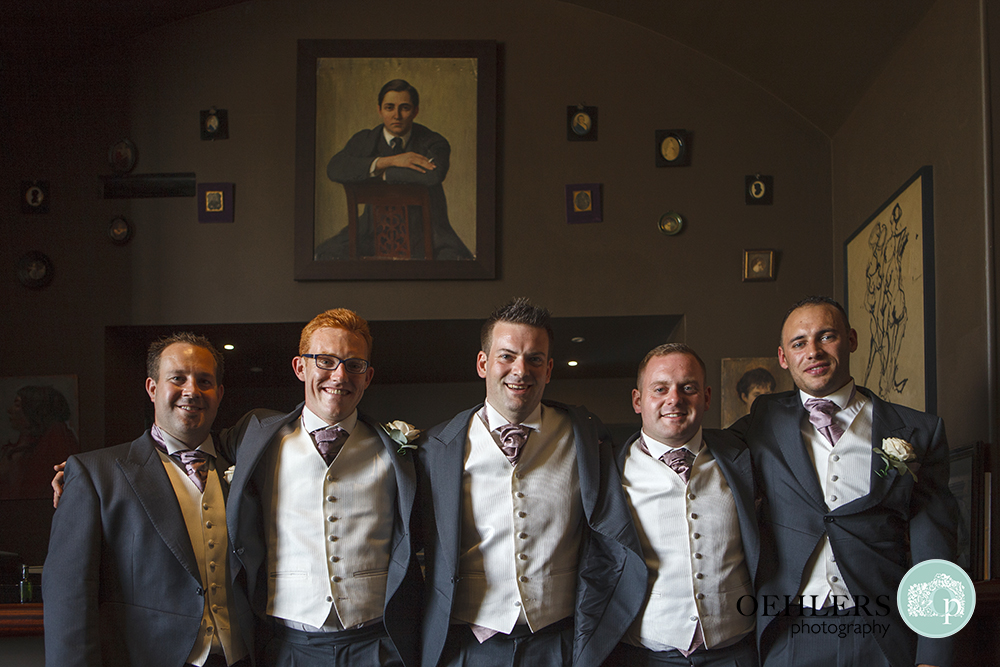 Groom with groomsmen posing in the bar at Stubton Hall