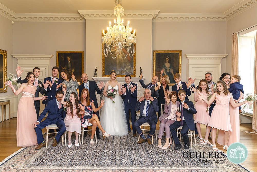 Indoor big group photograph of bride and groom with their families