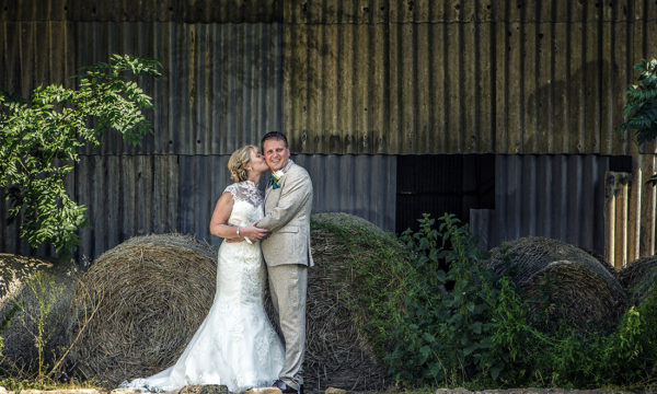 Bride and Groom in front of rustic background