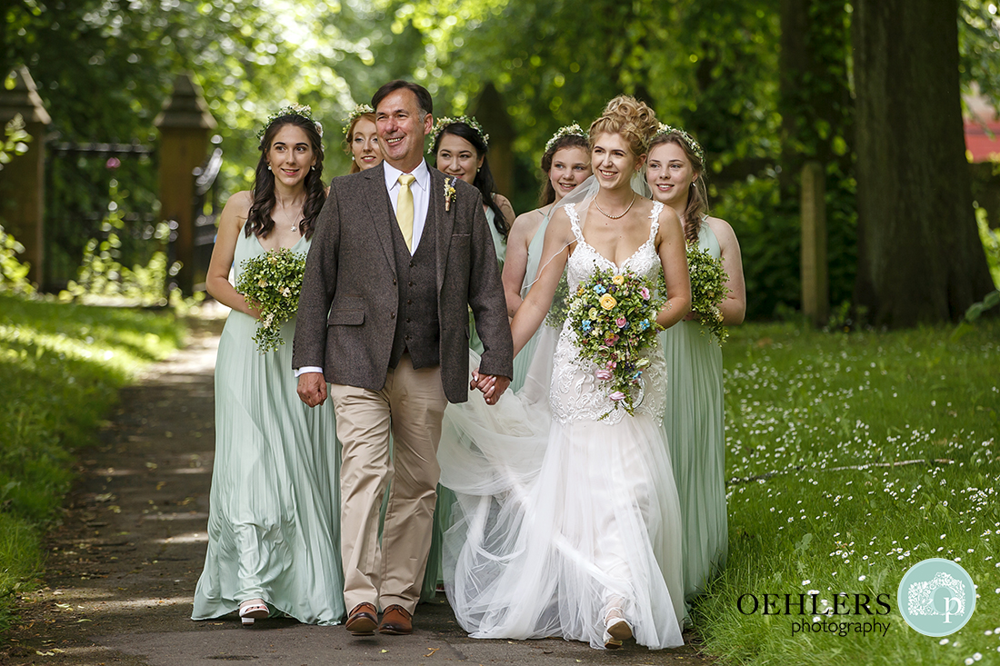 Bride and bridal party walking towards the church