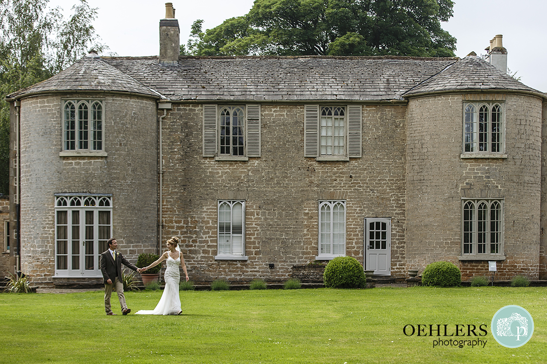 Bride and Groom walking in front of Cockliffe House