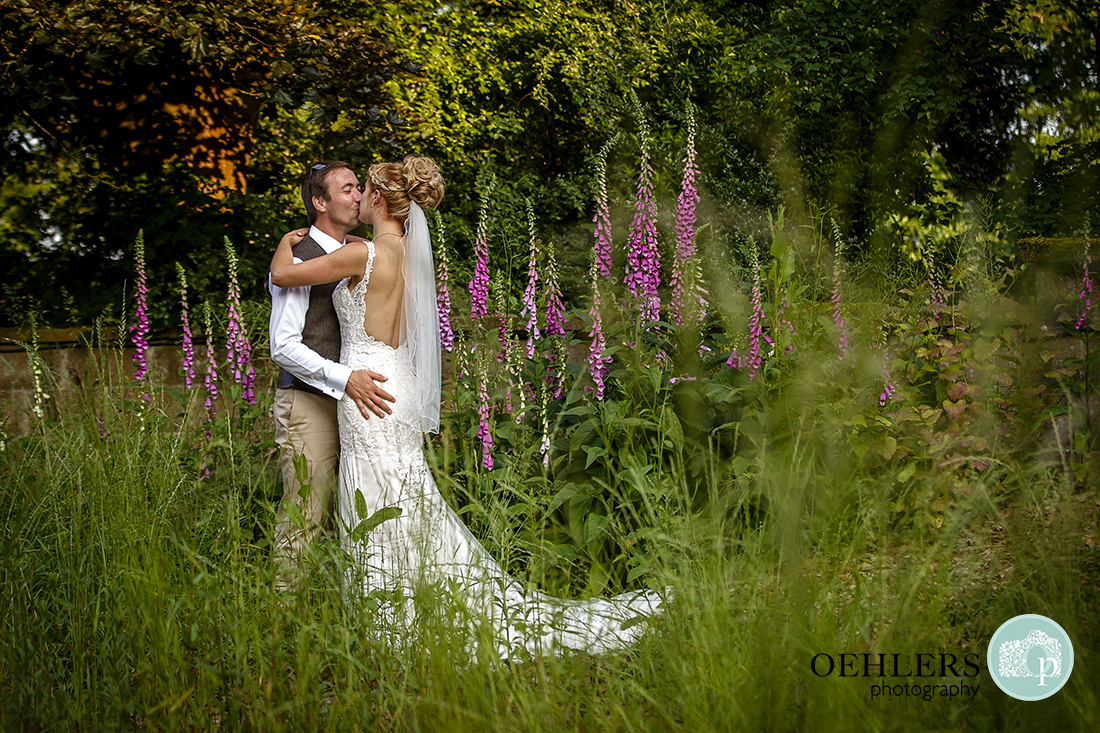 Bride and Groom having a kiss in the foxglove garden