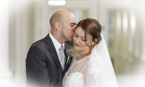 Groom kisses bride on the forehead