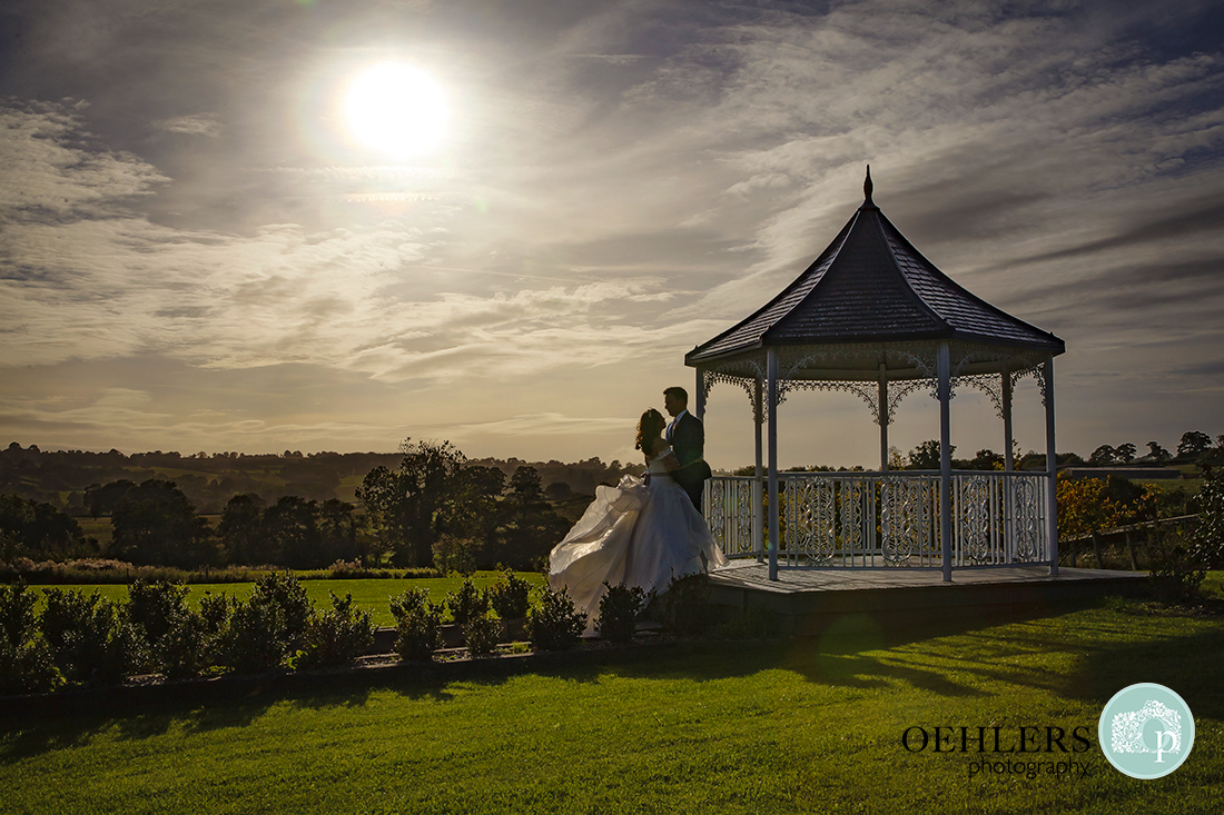 Romantic silhouette of the Bride and Groom at the gazebo