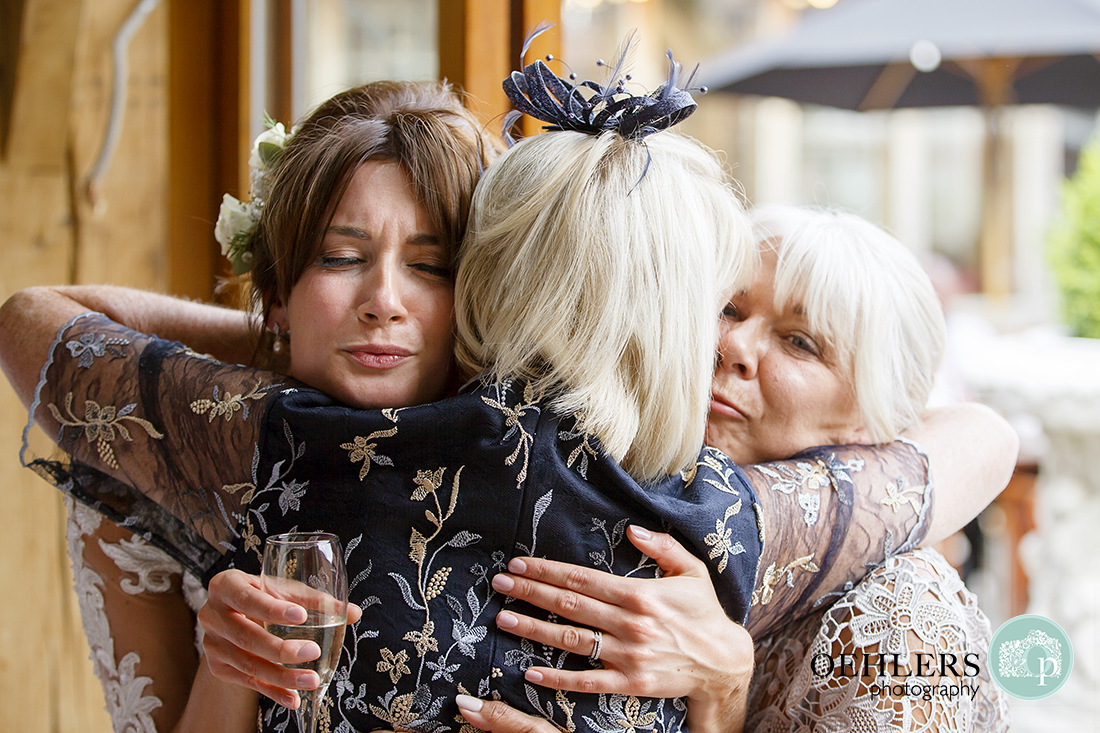 Bride having a huge cuddle from mum and aunty