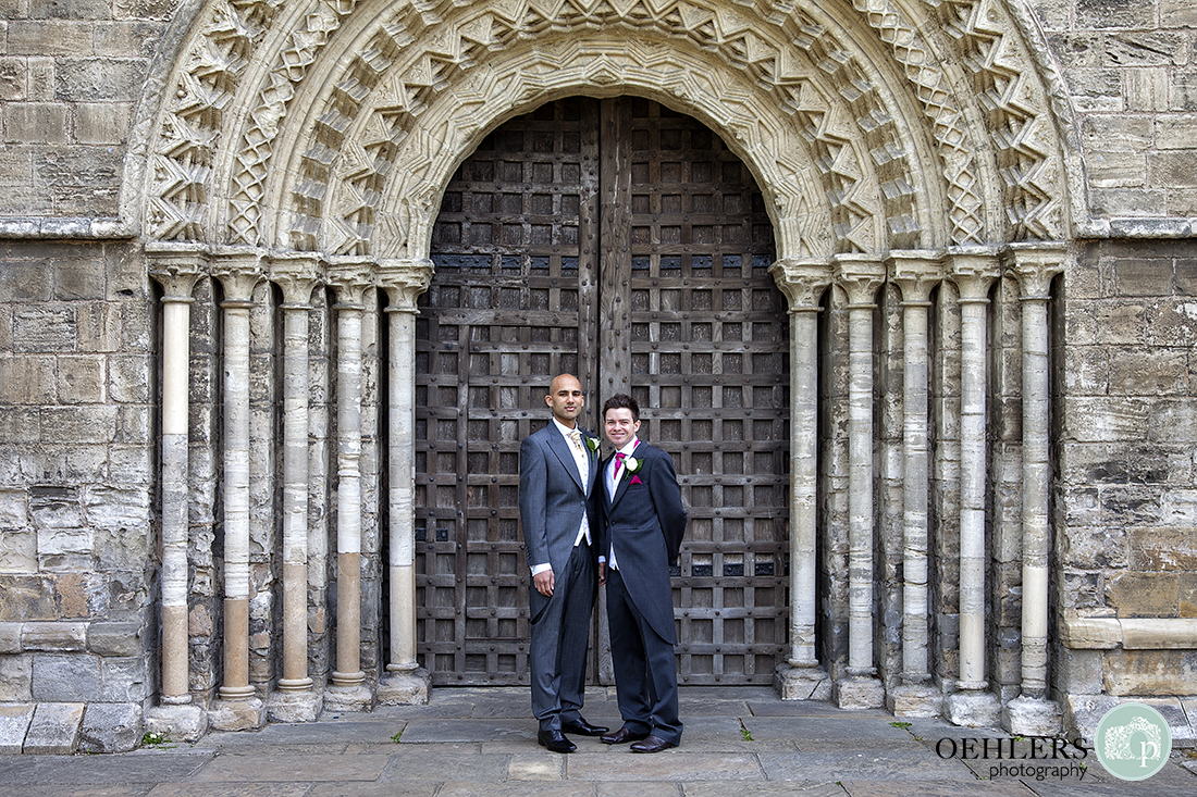 Groom and bestman posing in front of the beautiful entrance of Selby Abbey.