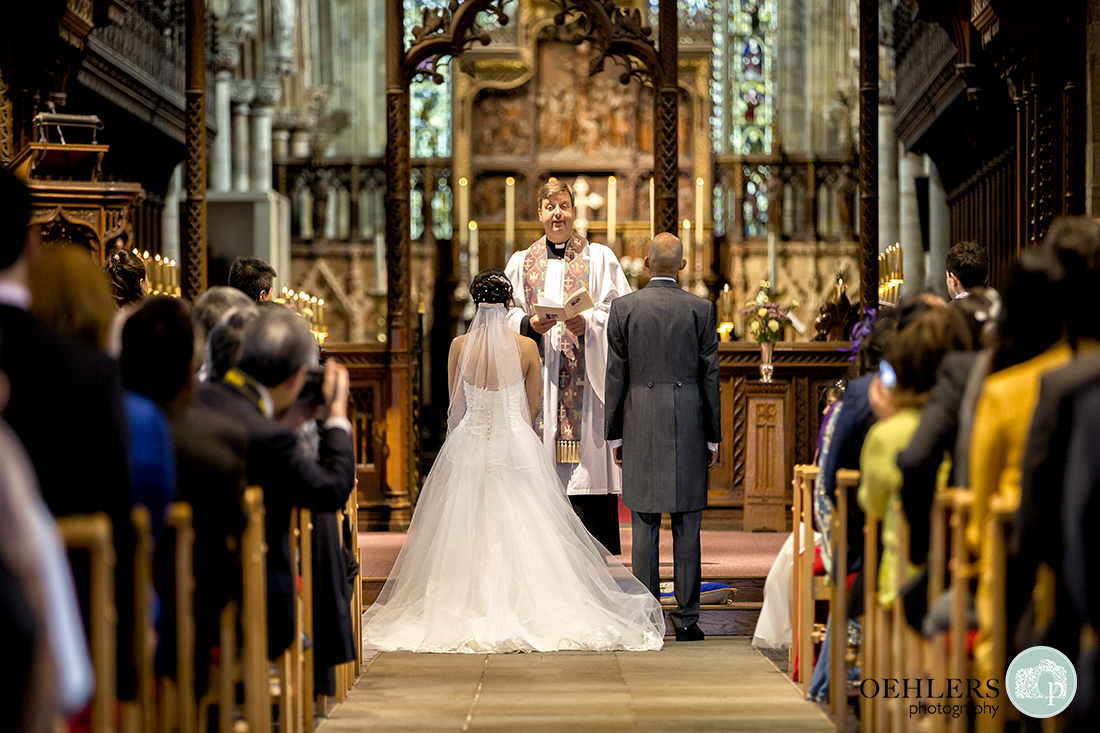 Looking down the aisle at the Bride and Groom in front of the clergyman ready to take their wedding vows.