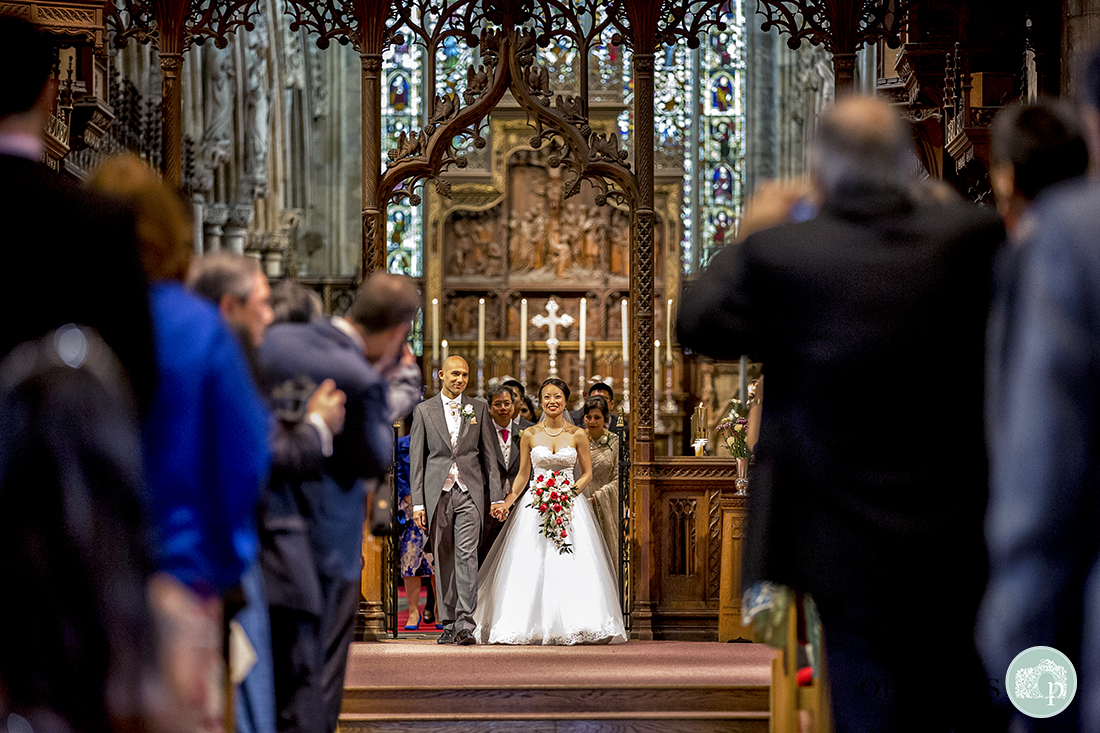 Bride and Groom walking back up the aisle followed by close family.