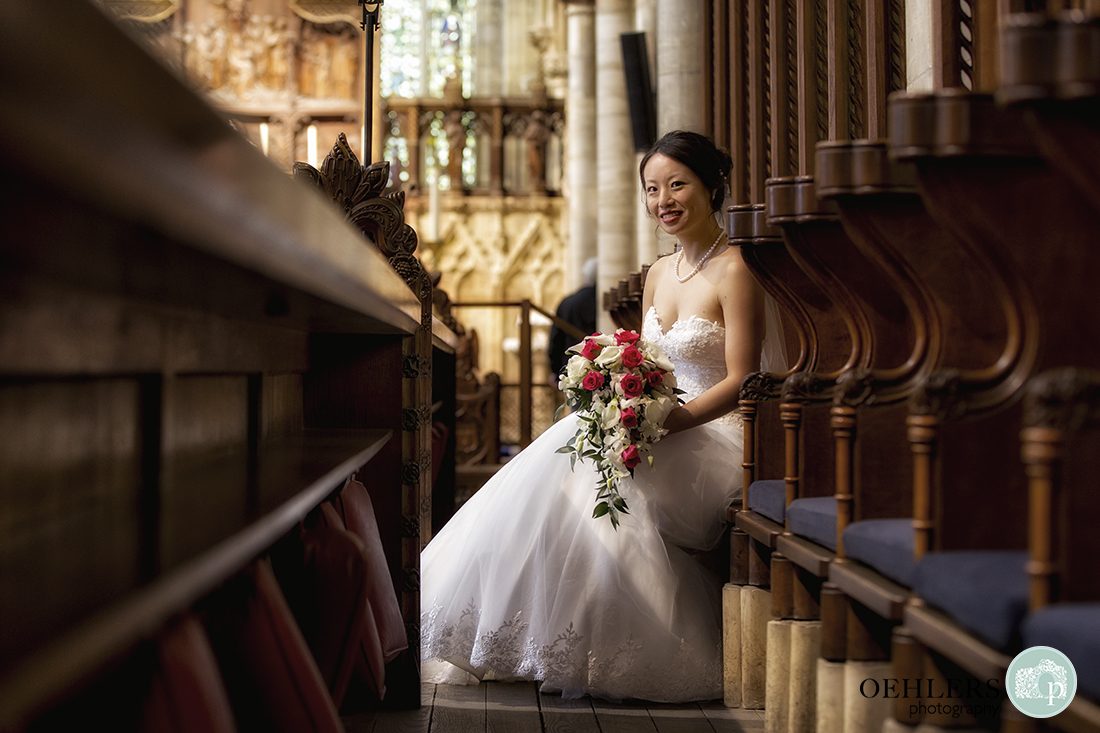 Beautiful portrait of bride sitting on a pew.