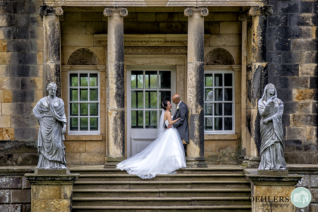 Bridal couple on the steps at The Temple of the Four Winds.