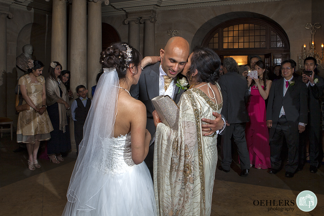 Mother of the Groom hugs and kisses her son on his cheek after the first dance.