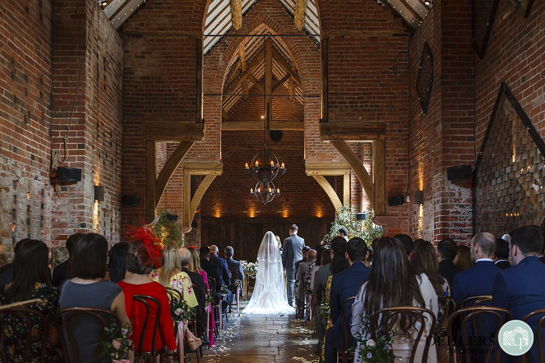 Shustoke Barn Wedding Photographers-View from the back of the wedding ceremony room at Shustoke Barn as bride and groom make theirs vows.