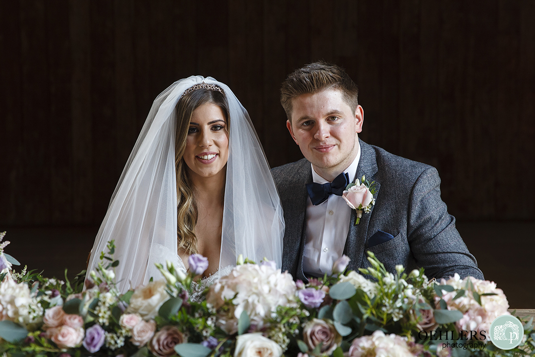 Shustoke Barn Wedding Photographers-Head shot of the newly married couple at faux signing of the marriage register.