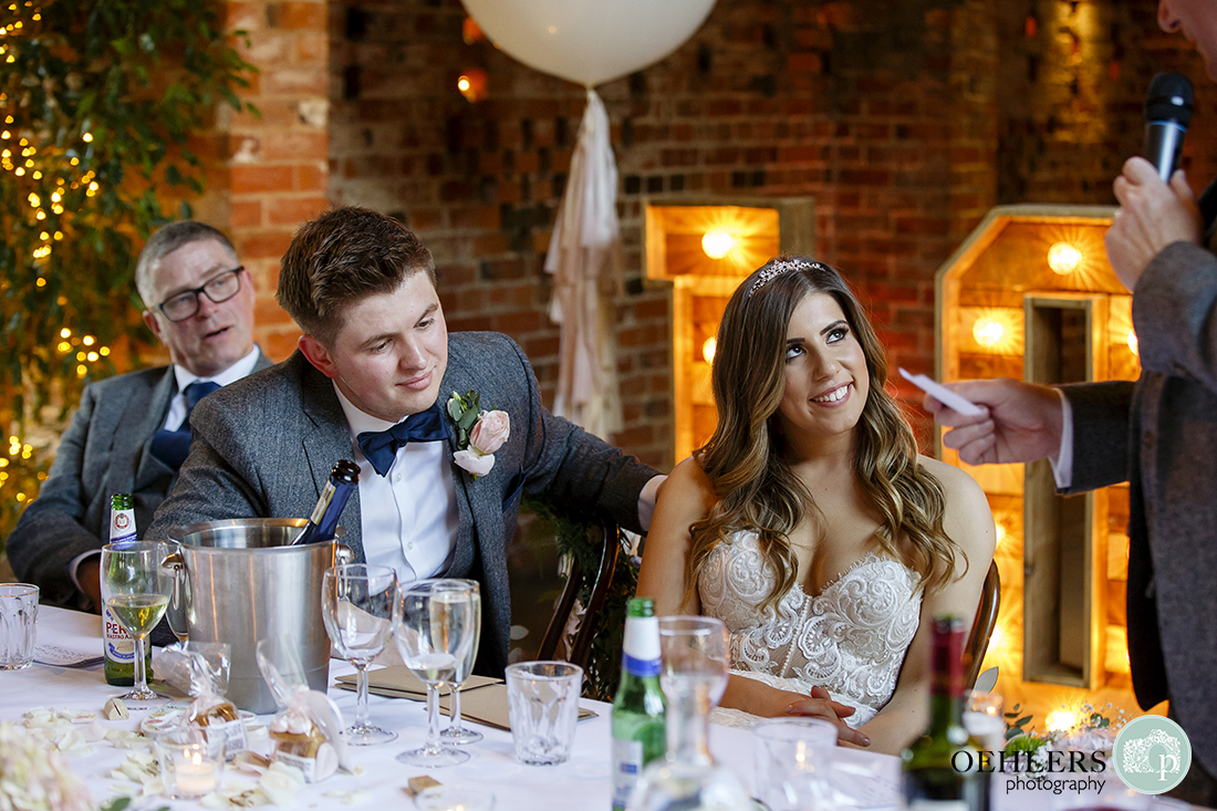 Shustoke Barn Wedding Photographers-Bride smiling and looking at her father during his speech.