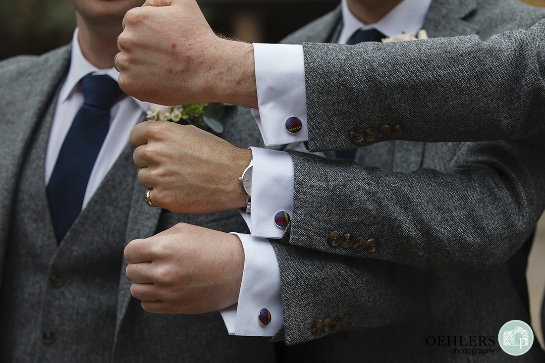 Three arms stacked on top of each other showing wedding cufflinks.