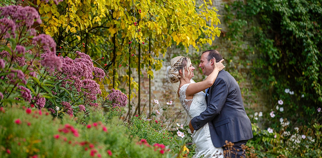 bride gazing into grooms eyes surrounded by beautiful flowers