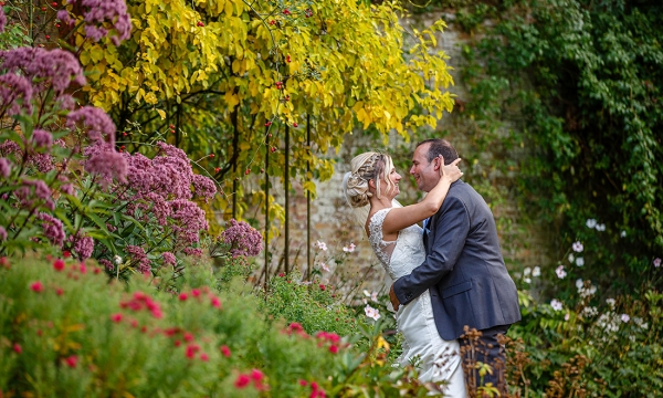 bride gazing into grooms eyes surrounded by beautiful flowers