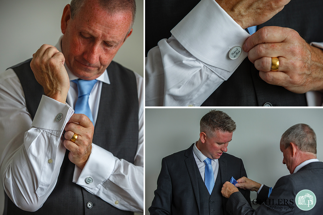 father of the bride putting on his cufflinks and helping his son get ready.