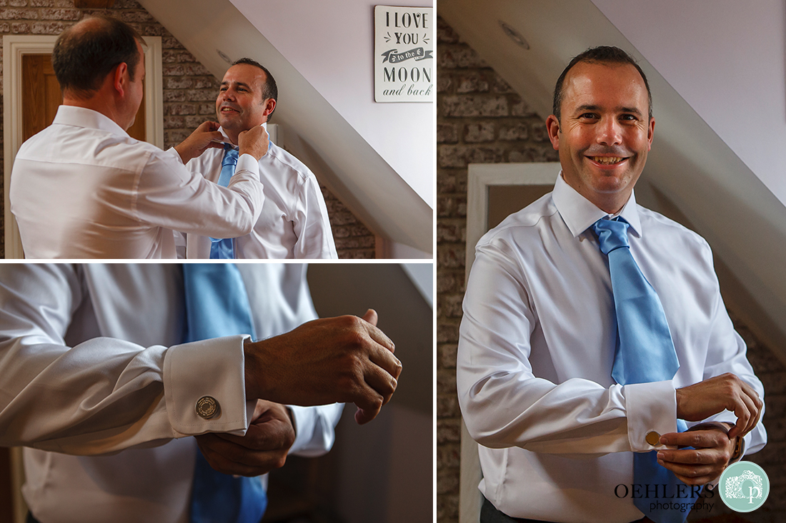 groom putting on his special cufflinks and bestman helping him to get ready