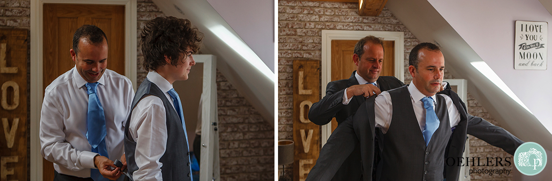 groom helping his son with his waistcoat and bestman putting on groom's jacket