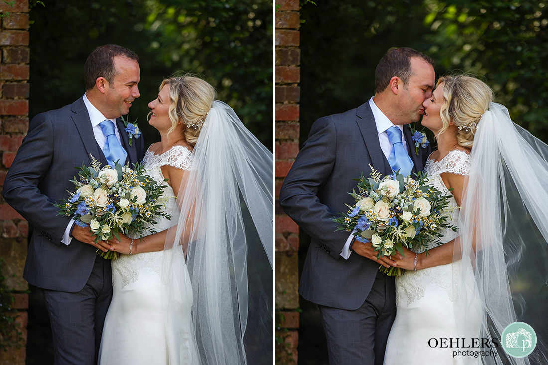 portrait of bride and groom looking at each other and then kissing in an archway