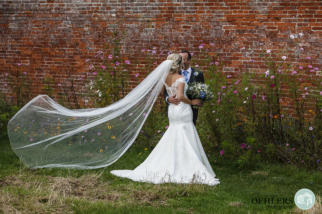 couple stealing a kiss with the veil blowing in the breeze