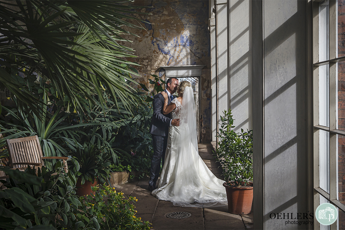 bride and groom stealing a moment in the orangery at Calke Abbey