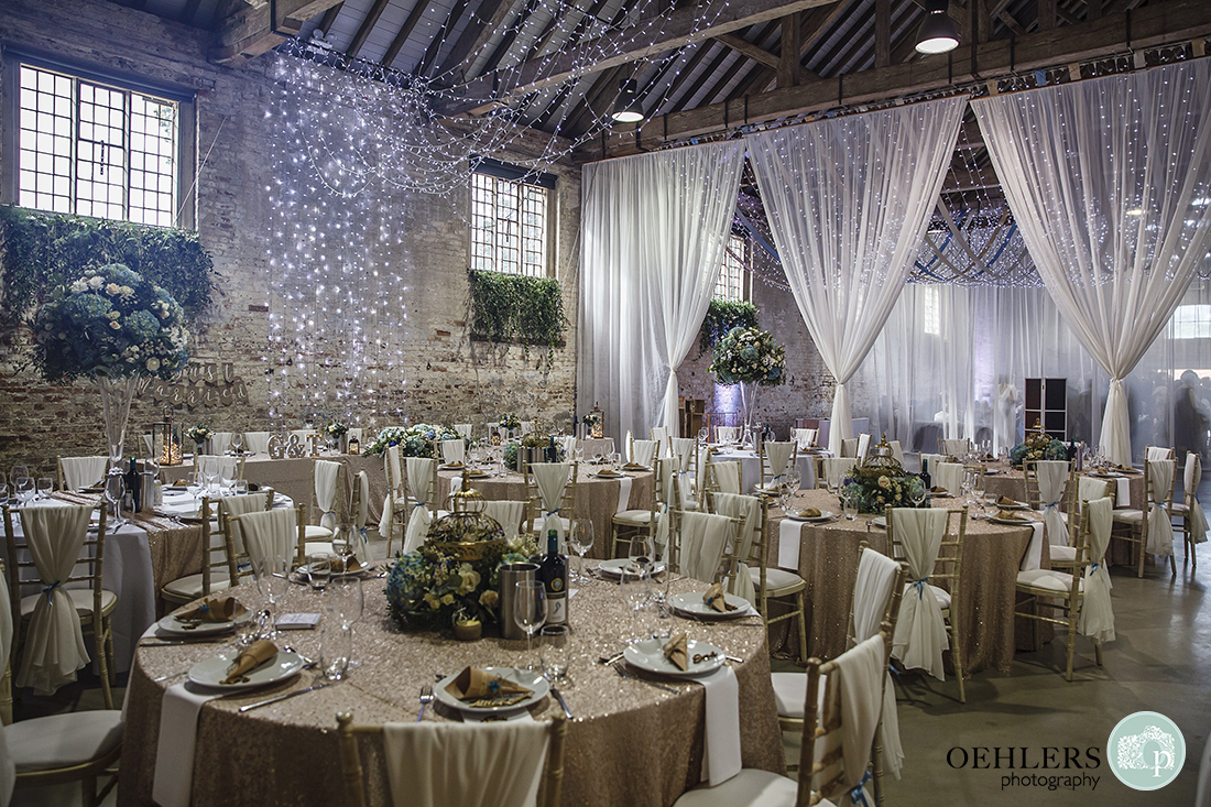 wedding breakfast room beautifully decorated with fairy lights and birdcages as centre pieces