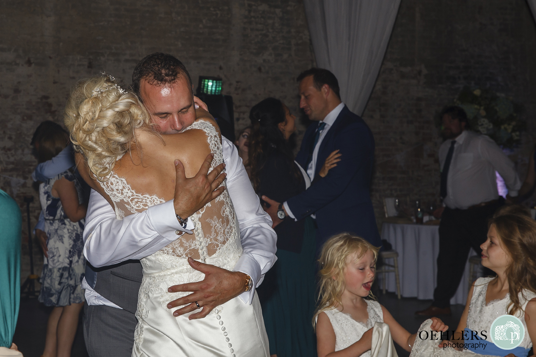 close up of the groom giving the bride a huge hug whilst dancing together