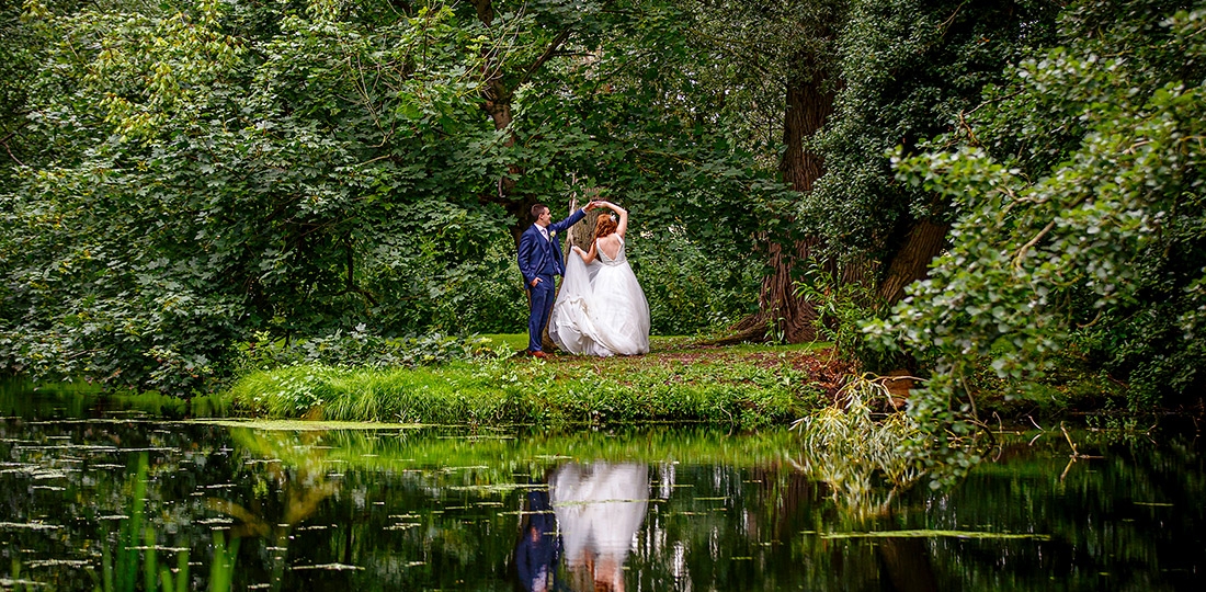 bride and groom dancing in front of the lake