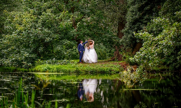 bride and groom dancing in front of the lake