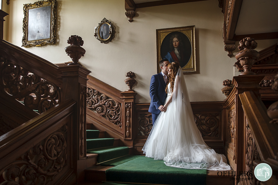 Bride and Groom on the beautiful engraved staircase of Thrumpton Hall.