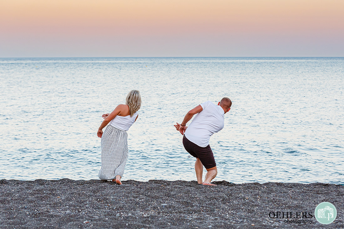 Santorini Wedding Photographers - couple skimming stones on Perissa Beach, Santorini.