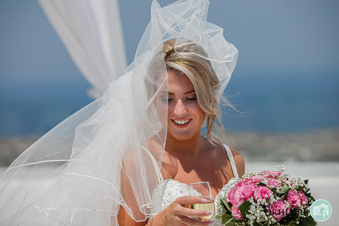 Santorini Destination Wedding Photographers - lovely, close-up photo of bride with champagne.