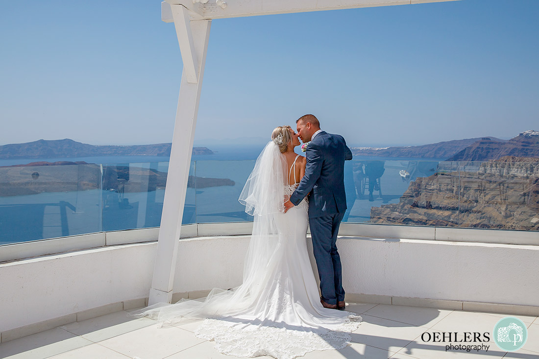 Santorini Destination Wedding Photographers - romantic photograph of bride and groom just about to kiss with beautiful backdrop.