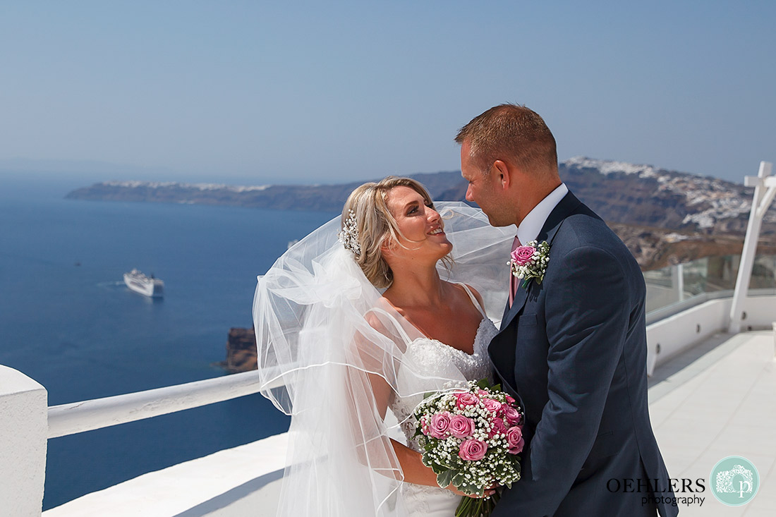 Destination Wedding Photographers - Santorini - bride and groom romantically looking into each others eyes.