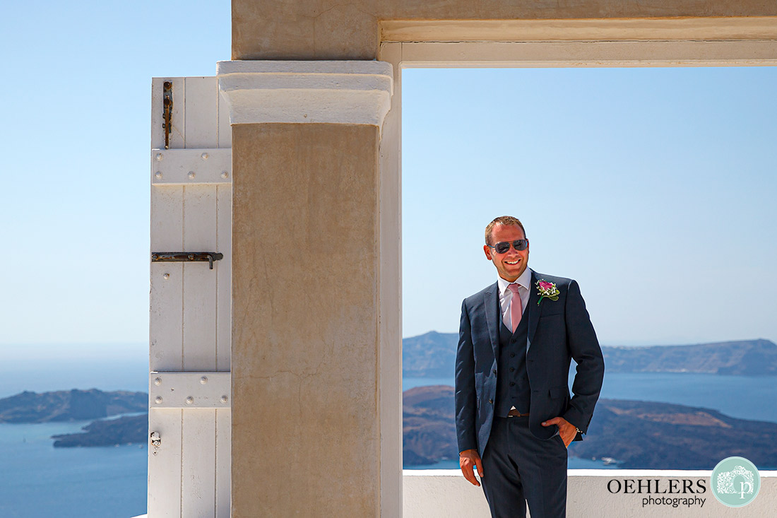 Cool groom posing in a doorway with great views behind.