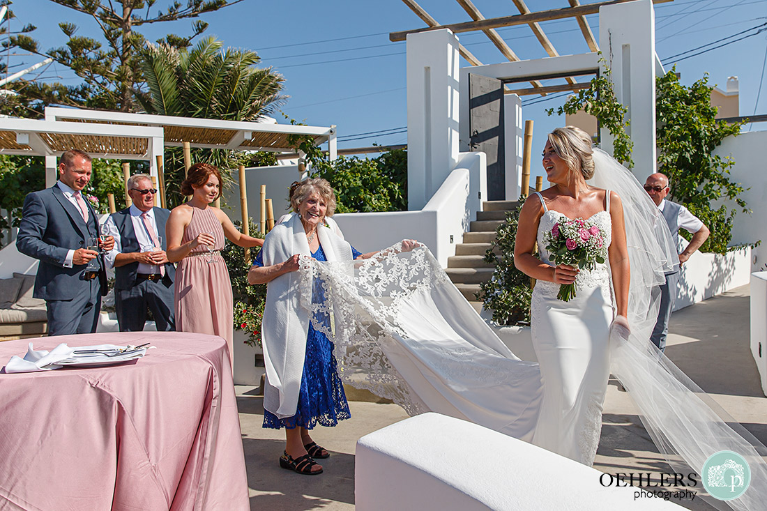 Grandmother holding the train of her granddaughter's wedding dress.