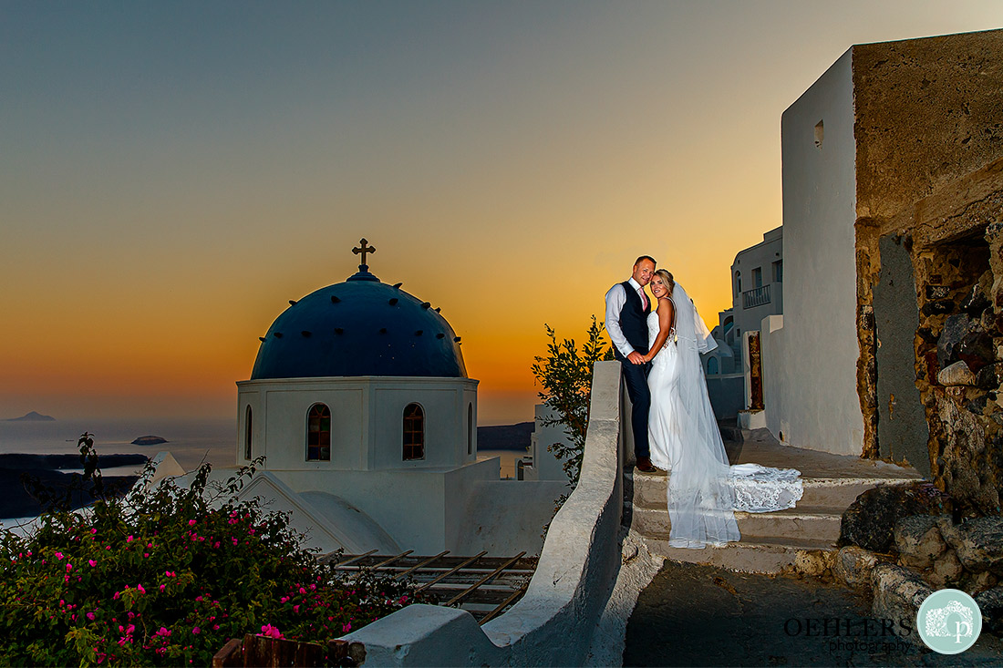 Beautiful sunset in the background with typical blue domed church in Imerovigli.