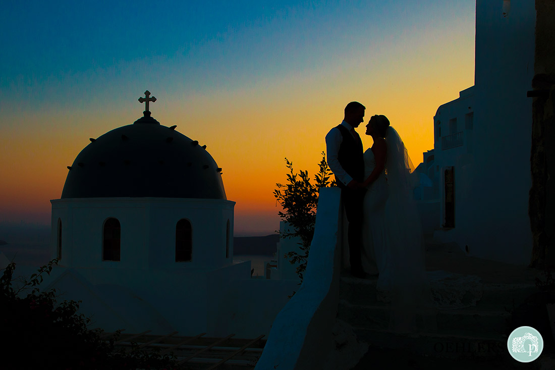 Santorini Wedding Photographer - silhuette of the bride and groom with sunset.